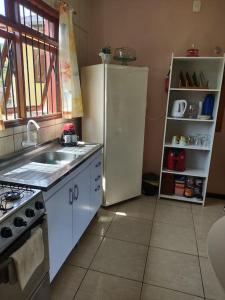 a kitchen with a white refrigerator and a sink at Pousada da Lua in Rolante