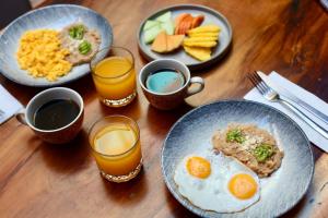 een houten tafel met borden met ontbijtproducten en -dranken bij Casa Pepe in Sayulita