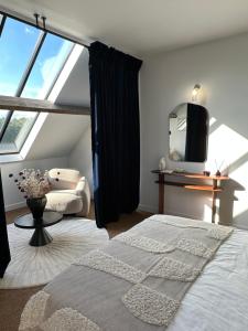 a bedroom with a bed and a large window at LA GRANDE MAISON LGM in Lesches