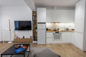 cocina con armarios blancos y mesa en Airbnb Kastoria - Bella Vista A, en Kastoria