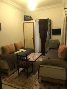 a living room with a couch and a table at Hôtel Riad Gnaoua in Essaouira