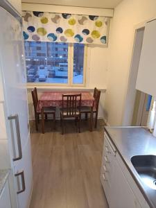 a kitchen with a table and chairs and a window at Huoneisto Kemin ydinkeskustassa in Kemi