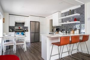 a kitchen with white cabinets and orange bar stools at "Ski" at Hills Meaford, Second Floor Suite w Bunk Beds in Meaford