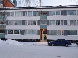 a blue car parked in front of a building at Huoneisto Kemin ydinkeskustassa in Kemi