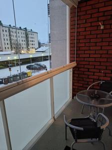 balcón con mesa, sillas y pared de ladrillo en Huoneisto Kemin ydinkeskustassa en Kemi