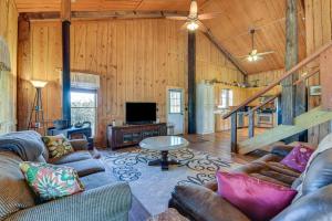 a living room with couches and a television in a cabin at Pet-Friendly Opp Vacation Rental with Spacious Deck! in Opp