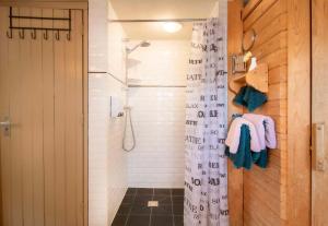 een badkamer met een douche en een douchegordijn bij B&B Noordzee-kerstdeco-Sauna-Strand7km-Kennemerduinen in Driehuis