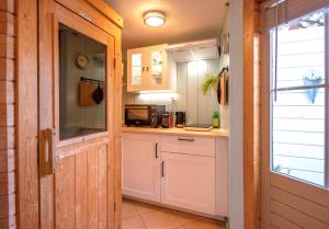 een keuken met een wastafel en een magnetron bij B&B Noordzee-kerstdeco-Sauna-Strand7km-Kennemerduinen in Driehuis