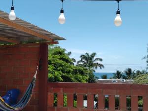 een hangmat op een hek met de oceaan op de achtergrond bij Hostal Casa Taisha in Montañita