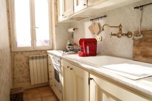 Casa di Amici - Garbatella في روما: مطبخ مع حوض و جهاز احمر
