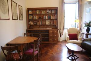 Casa di Amici - Garbatella في روما: غرفة معيشة مع طاولة ورف كتاب