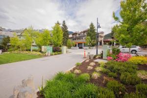 a driveway in a town with flowers and trees at Rainbow Lodge by Outpost Whistler in Whistler