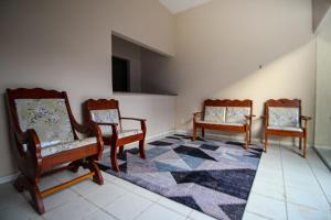 a room with three chairs and a rug at Hotel e Hostel da Fonte in São Luís