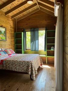 ein Schlafzimmer mit einem Bett in einer Holzhütte in der Unterkunft CASITAS GINGER in Quepos