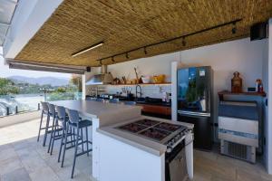 a kitchen with a counter with a stove and a refrigerator at “Casa de alto padrão com ampla vista para o mar.” in Ubatuba