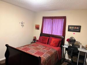 a bedroom with a bed with red pillows and a window at Quiet and Beautiful home in Montgomery