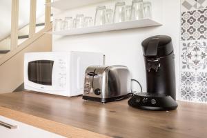 um balcão de cozinha com um micro-ondas e comodidades para preparar café em Maison Juliette, maison à la campagne em Comines