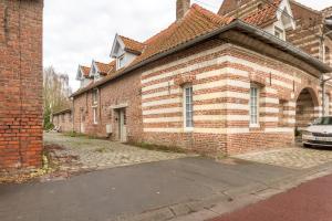 Comines的住宿－Maison Juliette, maison à la campagne，前面有停车位的砖砌建筑