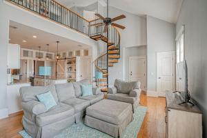 a living room with a couch and a spiral staircase at Habersham Retreat on Abbey Row in Beaufort