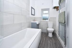 a white bathroom with a tub and a toilet at Lyndale Lofts - By Sigma Stays in Crewe