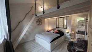 een kleine slaapkamer met een bed en een trap bij Gîte 4/6 personnes La mélodie du bonheur in Habas
