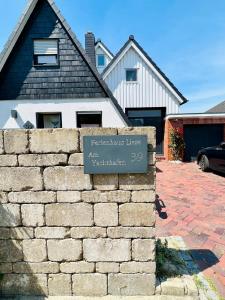 ein Schild an einer Backsteinmauer vor einem Haus in der Unterkunft Ferienhaus Liese in Carolinensiel