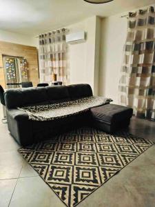 a living room with a black couch and a rug at Stella Apartment in Palermo