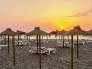 a group of chairs and umbrellas on the beach at sunset at Los Alamos Beach - Parking in Torremolinos