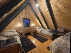 a room with three beds in a wooden cabin at Vikendica Bulat in Blidinje