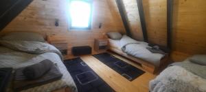a room with two beds in a wooden cabin at Vikendica Bulat in Blidinje