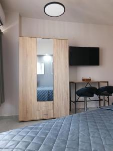 - une chambre avec une porte coulissante, un lit et une télévision dans l'établissement Central Studio in Veria, à Véria