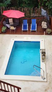 una piscina con due sedie e un ombrellone di Caribbean Dream Vacation Property CD1 a Gros Islet