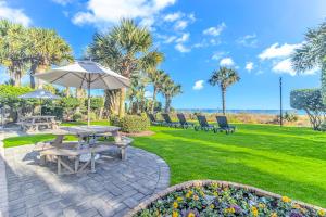 a picnic table with an umbrella in a park at Stunning Oceanfront 2 Bedroom Suite- Sailfish Resort 1111 in Myrtle Beach