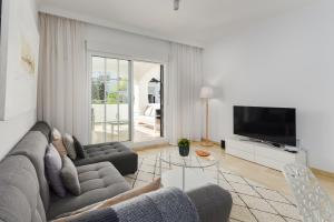 ein Wohnzimmer mit Sofa und Fernseher in der Unterkunft Casa Beau Bella 2-bedroom apartment at Residencial Duquesa in Manilva
