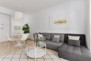ein Wohnzimmer mit einer grauen Couch und einem Tisch in der Unterkunft Casa Beau Bella 2-bedroom apartment at Residencial Duquesa in Manilva