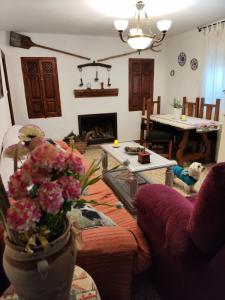 ein Wohnzimmer mit einer Blumenvase auf dem Tisch in der Unterkunft Casa Rural CUARTELILLOS in Sabariego