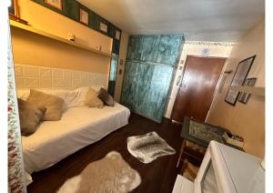 a bedroom with a white bed and a wooden floor at Appartamenti Sud Ovest By MountainHouses in Sestriere