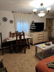 a living room with a table and chairs and a tv at Casa Rural CUARTELILLOS in Sabariego