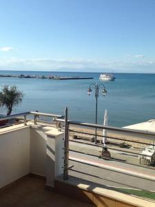 a balcony with a view of the water and a boat at Sea and Sun Luxury apartment in Neoi Epivates