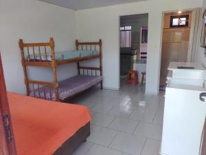 Habitación con cama y cocina con mesa en Residencial Caiobá I, en Matinhos
