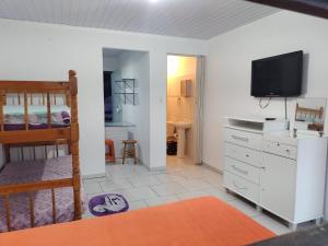 Residencial Caiobá I في ماتينيوس: غرفة نوم مع سرير بطابقين وتلفزيون