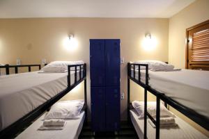 Hotel e Hostel da Fonte في ساو لويس: غرفة بسريرين بطابقين وخزانة زرقاء