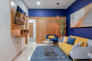 un salon avec un canapé jaune et un mur bleu dans l'établissement LOFT El Azul en Centro Historico con Cama King, à Durango