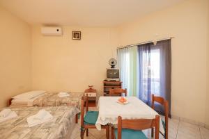 una camera con due letti, un tavolo e una televisione di Beachfront apartments Jermen a Sukošan (San Cassiano)
