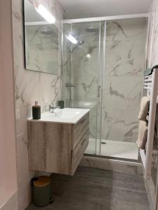 a white bathroom with a shower and a sink at La Mezzavilla in Nuits-Saint-Georges