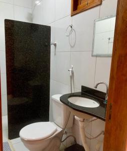 een badkamer met een toilet, een wastafel en een douche bij POUSADA NOVO HORIZONTE in Martins