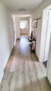 um corredor de um quarto vazio com piso de madeira em DG Links -Wunderschöne 40m² große City Wohnung nähe Salzburg em Freilassing