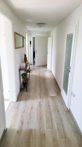 an empty hallway with wooden floors and white walls at DG Links -Wunderschöne 40m² große City Wohnung nähe Salzburg in Freilassing