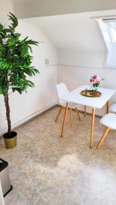 uma mesa branca e cadeiras num quarto com uma planta em DG Links -Wunderschöne 40m² große City Wohnung nähe Salzburg em Freilassing