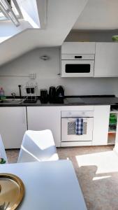 eine weiße Küche mit einer Spüle und einem Herd in der Unterkunft DG Links -Wunderschöne 40m² große City Wohnung nähe Salzburg in Freilassing